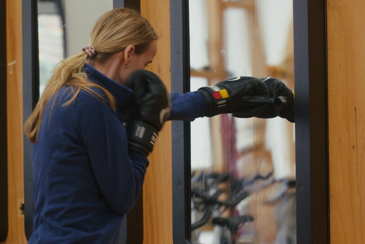 Combat Mirror in use at a boxing gym, training in front of the wall-mounted mirror.