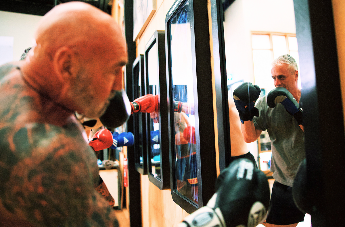 Combat Mirror in use at a boxing gym, training in front of the wall-mounted mirror.